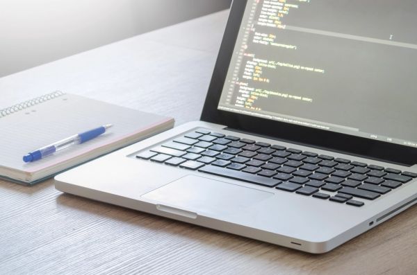 ノートパソコンの画面に表示されたWebデザインのコード