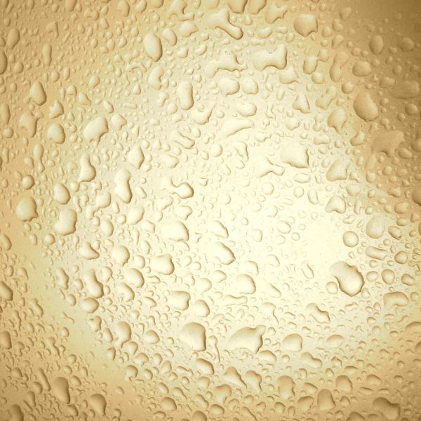 水滴がガラス面で光を屈折させる質感のクローズアップ写真